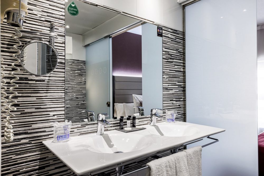 Bathroom mirror and lighting in a Superior Room at Hotel Ronda Lesseps